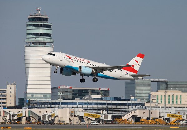 Flugzeug beim Starten vor dem Tower des Flughafens Wien Schwechat