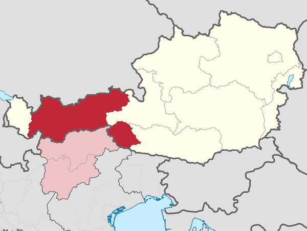 Tirol in Österreich - rot: Nordtirol (links), Osttirol (rechts); in Italien - rosa: Südtirol (oben), Welschtirol (unten)